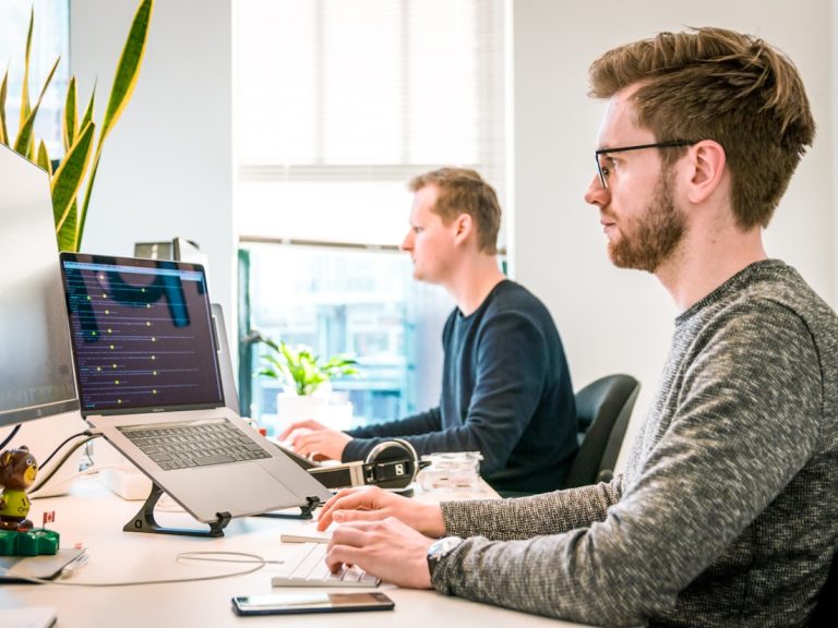 Equipo de desarrollo trabajando frente a paneles administrativos